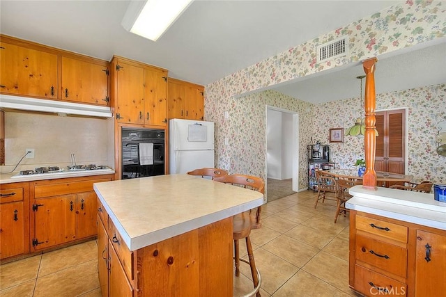 18021 E Cypress St, Covina, CA 91722 - kitchen with white appliances, wallpapered walls, under cabinet range hood, light countertops, and light tile patterned flooring