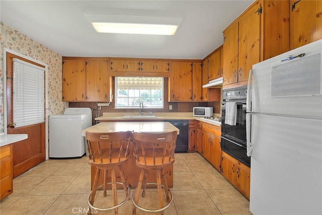 18021 E Cypress St, Covina, CA 91722 - kitchen with black appliances, a warming drawer, a sink, light countertops, and light tile patterned floors