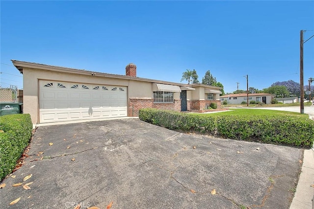18021 E Cypress St, Covina, CA 91722 - ranch-style home with brick siding, a chimney, driveway, a garage, and stucco siding