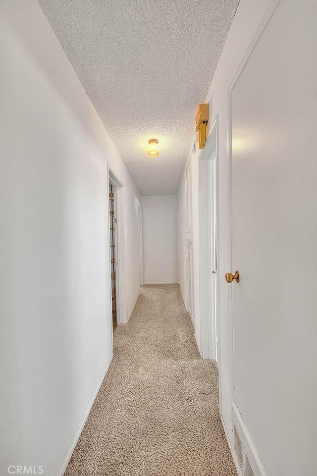 18021 E Cypress St, Covina, CA 91722 - hallway featuring a textured ceiling, light carpet, and baseboards