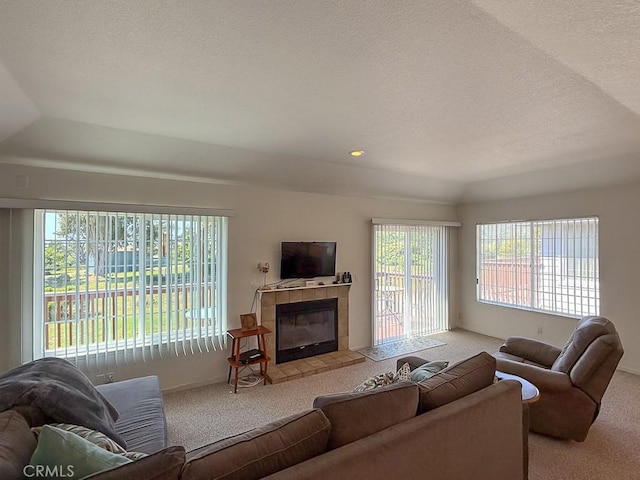 540 Pico Ave Unit 110, San Simeon, CA 93452 - carpeted living room featuring a tiled fireplace, a textured ceiling, and vaulted ceiling