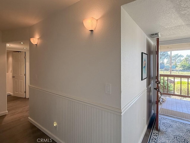 540 Pico Ave Unit 110, San Simeon, CA 93452 - corridor with wood finished floors, a wainscoted wall, and a textured ceiling