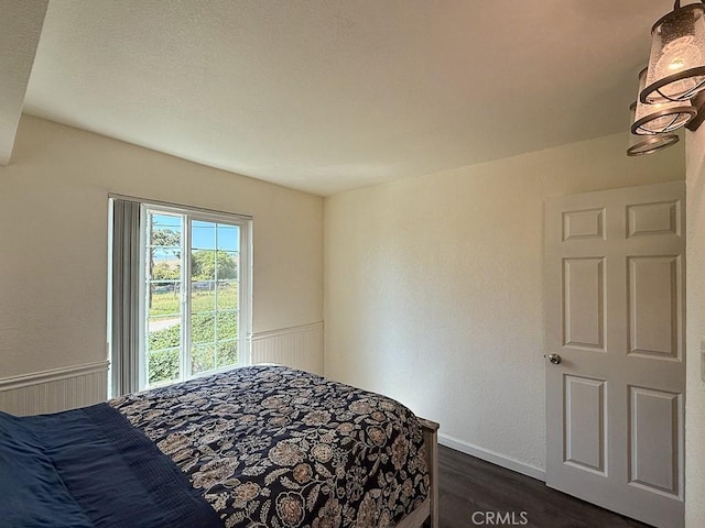 540 Pico Ave Unit 110, San Simeon, CA 93452 - bedroom featuring dark wood-style floors and a wainscoted wall