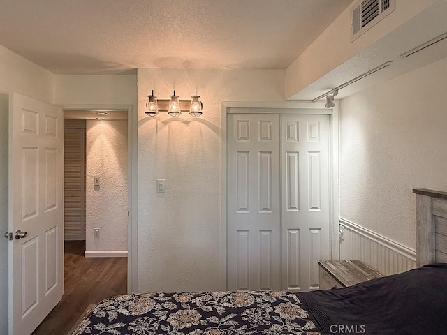 540 Pico Ave Unit 110, San Simeon, CA 93452 - bedroom featuring dark wood finished floors, a textured wall, and a closet