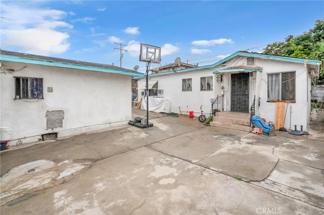 back of house featuring stucco siding, a patio, and entry steps