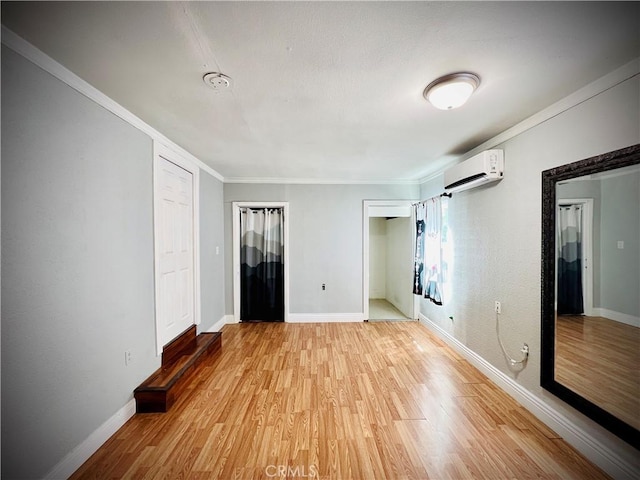 945 N Dickel St, Anaheim, CA 92805 - unfurnished bedroom featuring a wall mounted AC, light wood-type flooring, two closets, baseboards, and crown molding