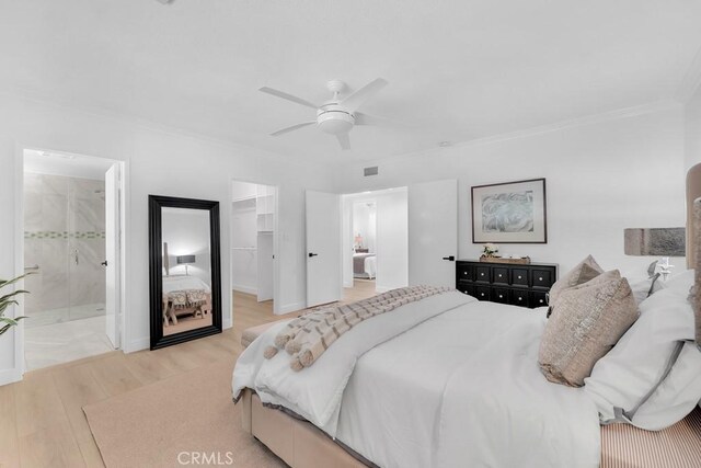 bedroom featuring a walk in closet, wood finished floors, crown molding, a closet, and ceiling fan