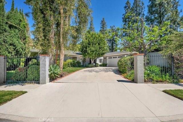 obstructed view of property with concrete driveway, a garage, and fence
