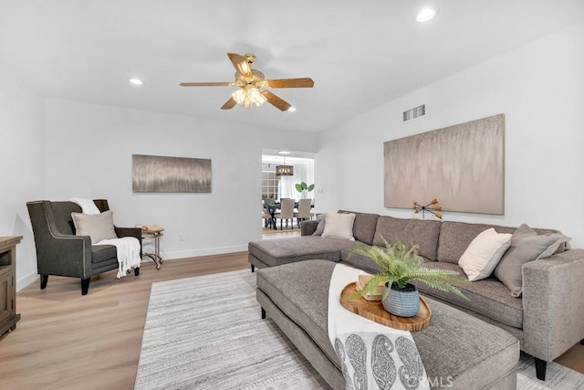 living room with light wood-style floors, a ceiling fan, baseboards, and recessed lighting