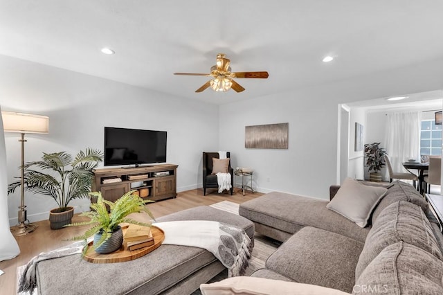 living room with a ceiling fan, light wood finished floors, baseboards, and recessed lighting