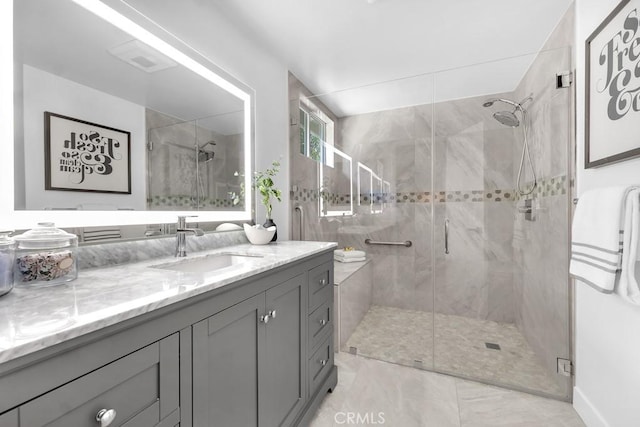 full bath featuring a shower stall, vanity, and marble finish floors