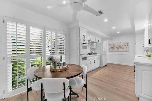 dining area with baseboards, light wood-style floors, ceiling fan, and recessed lighting