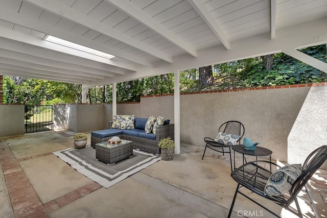 view of patio / terrace with an outdoor living space, fence, and a gate