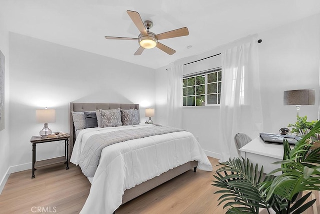 bedroom featuring light wood-style floors, baseboards, and a ceiling fan