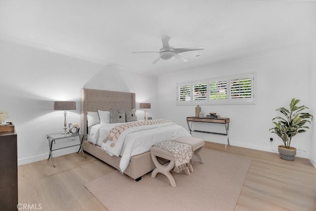 bedroom with light wood-style floors, baseboards, crown molding, and ceiling fan
