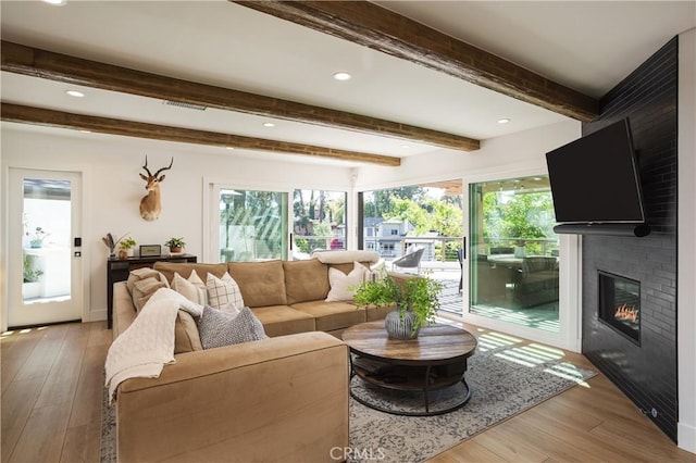 2315 Heather Ln, Newport Beach, CA 92660 - living area featuring healthy amount of natural light, light wood finished floors, beam ceiling, a large fireplace, and recessed lighting