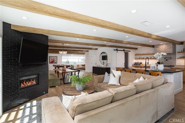 2315 Heather Ln, Newport Beach, CA 92660 - living area featuring a barn door, wood finished floors, beamed ceiling, recessed lighting, and a tiled fireplace