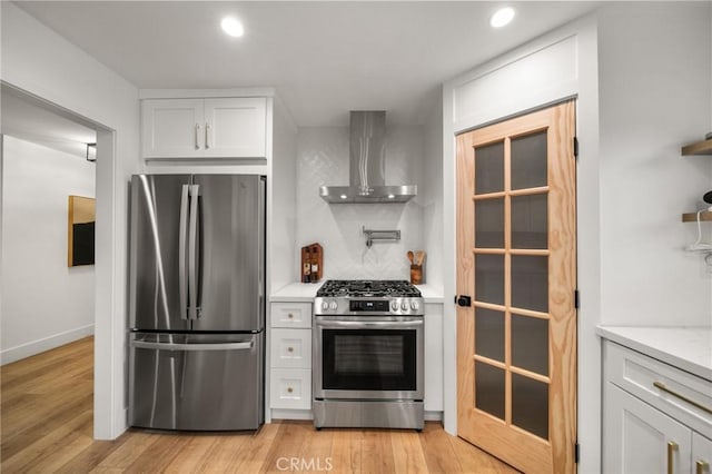 2812 Loyola St, Riverside, CA 92503 - kitchen with appliances with stainless steel finishes, wall chimney range hood, recessed lighting, light wood-type flooring, and white cabinets