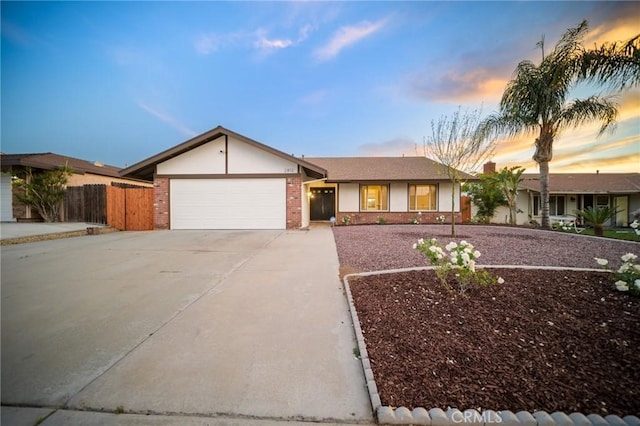 2812 Loyola St, Riverside, CA 92503 - ranch-style house with concrete driveway, fence, an attached garage, and brick siding