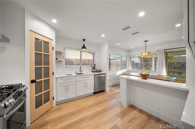 2812 Loyola St, Riverside, CA 92503 - kitchen featuring appliances with stainless steel finishes, light wood-type flooring, decorative light fixtures, white cabinets, and recessed lighting