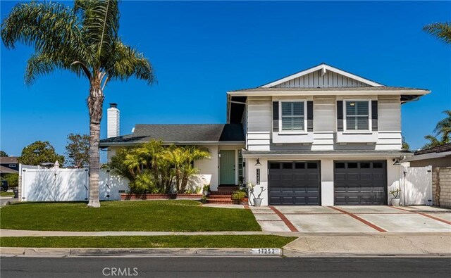 17252 Breda Ln, Huntington Beach, CA 92649 - split level home with a garage, driveway, a gate, stucco siding, and a chimney
