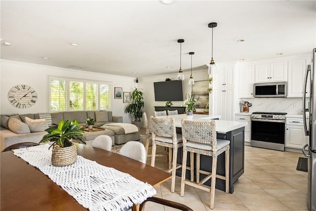 17252 Breda Ln, Huntington Beach, CA 92649 - kitchen featuring appliances with stainless steel finishes, open floor plan, ornamental molding, light countertops, and white cabinets