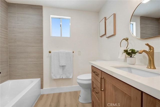 full bathroom featuring wood finished floors, toilet, vanity, and baseboards