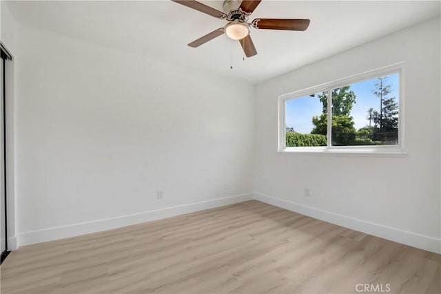 spare room with light wood-style flooring, baseboards, and a ceiling fan