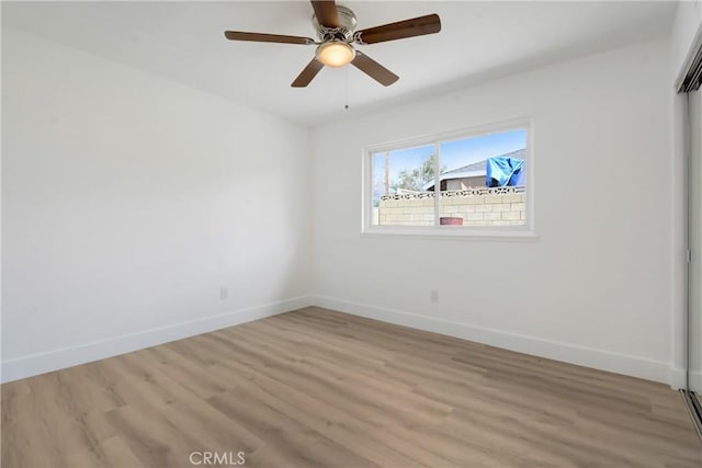 unfurnished bedroom with baseboards, light wood-type flooring, a closet, and a ceiling fan