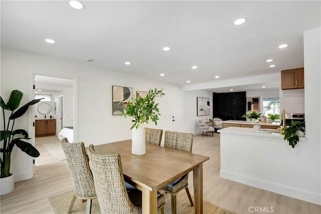 dining area with light wood-style flooring and recessed lighting