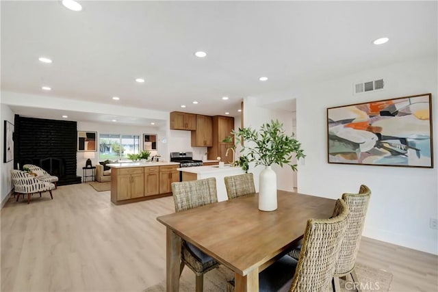 6445 Beryl St, Rancho Cucamonga, CA 91701 - dining room featuring light wood-style flooring, recessed lighting, a fireplace, and baseboards