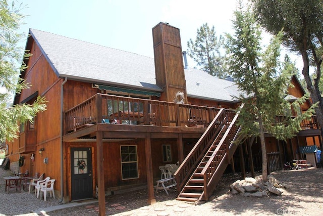 2205 Freeman Dr, Pine Mountain Club, CA 93225 - rear view of house with roof with shingles, a deck, a chimney, and stairway