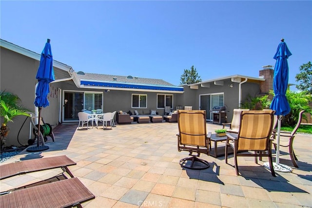 back of property with an outdoor hangout area, stucco siding, a patio, and outdoor dining area