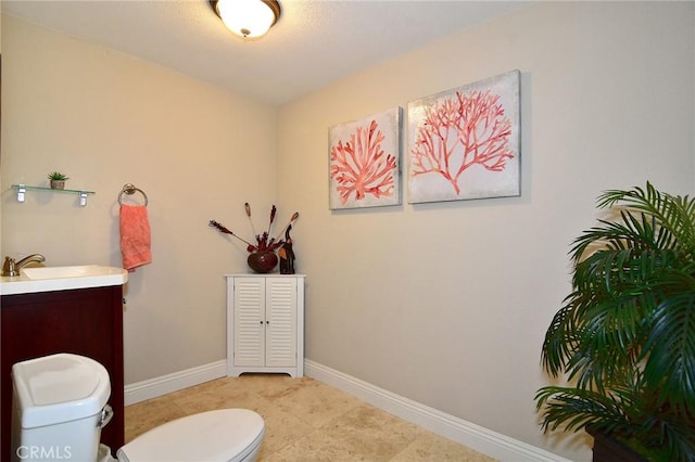 bathroom with toilet, vanity, baseboards, and tile patterned floors