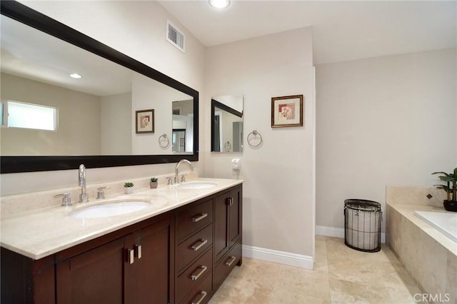 bathroom featuring double vanity, tiled tub, recessed lighting, and baseboards