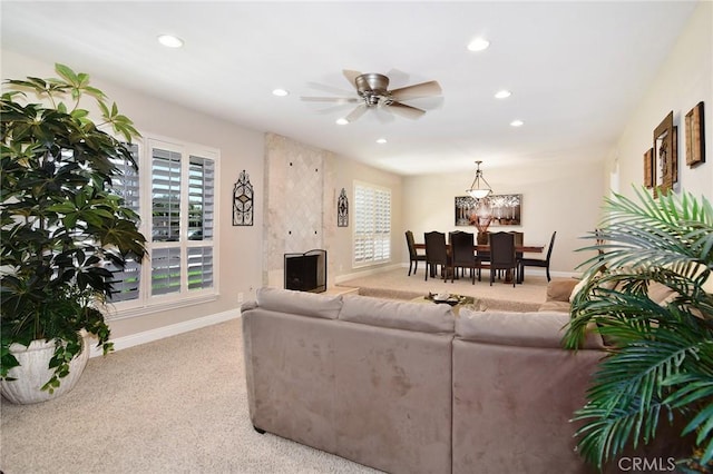 carpeted living area with healthy amount of natural light, recessed lighting, baseboards, ceiling fan, and a fireplace
