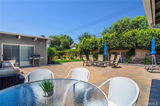 view of patio featuring outdoor dining space, grilling area, a fenced backyard, and outdoor lounge area