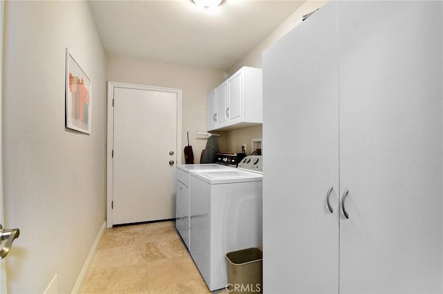laundry area with washing machine and clothes dryer, cabinet space, and baseboards