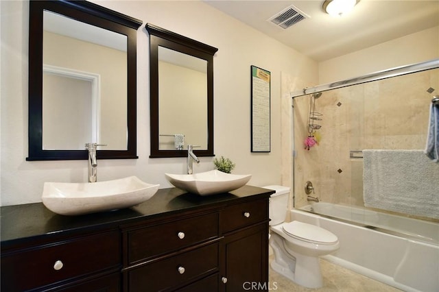 full bathroom with enclosed tub / shower combo, double vanity, toilet, and tile patterned floors
