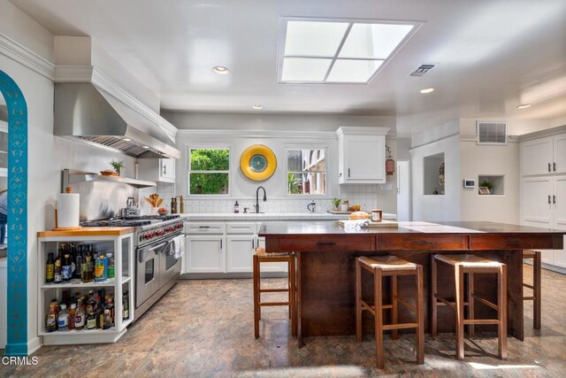2707 Hermosita Dr, Glendale, CA 91208 - kitchen with double oven range, a kitchen island, open shelves, backsplash, and a breakfast bar area
