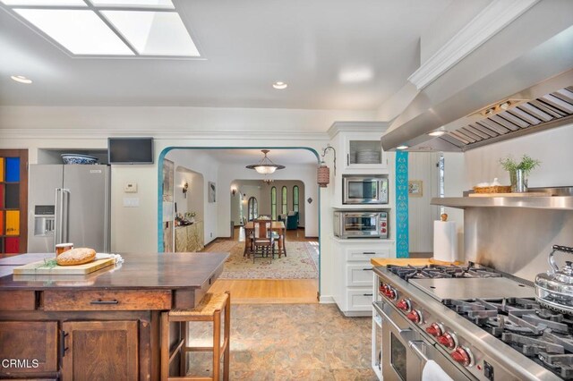 2707 Hermosita Dr, Glendale, CA 91208 - kitchen with high end appliances, wall chimney exhaust hood, arched walkways, white cabinets, and glass insert cabinets