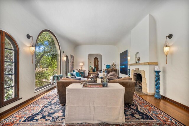 2707 Hermosita Dr, Glendale, CA 91208 - living area featuring wood finished floors, a fireplace, arched walkways, and baseboards