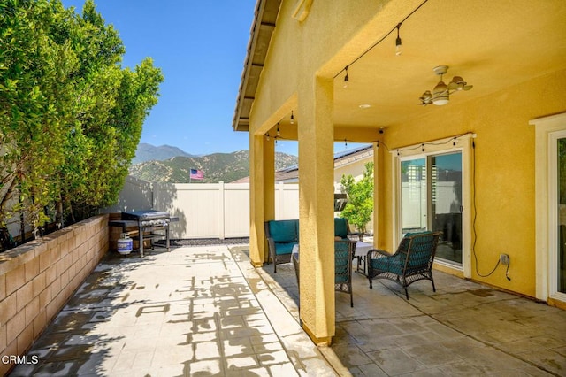 view of patio featuring a mountain view and fence