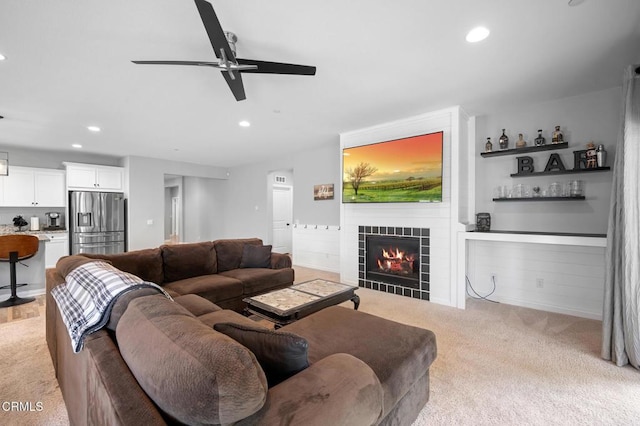 living area featuring light carpet, recessed lighting, a tile fireplace, and ceiling fan