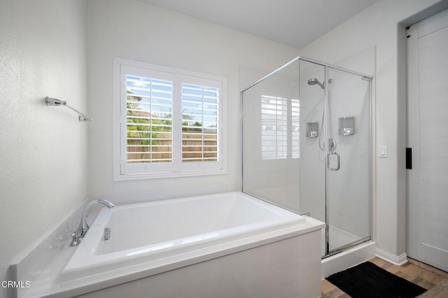 full bathroom with a shower stall, a bath, and wood finished floors