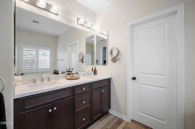 17837 Grapevine Ln, San Bernardino, CA 92407 - bathroom with double vanity and wood finished floors