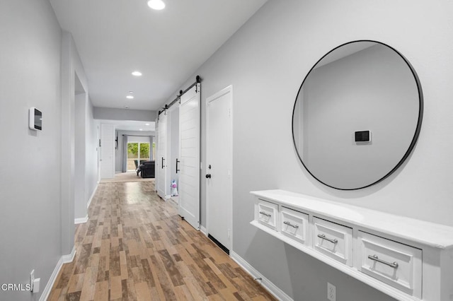 17837 Grapevine Ln, San Bernardino, CA 92407 - corridor featuring a barn door, light wood finished floors, and recessed lighting