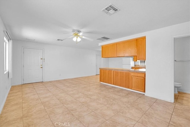 72454 El Paseo Dr Unit 29, Palms, CA 92277 - kitchen with a ceiling fan, a peninsula, freestanding refrigerator, light countertops, and open floor plan