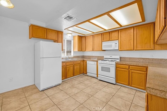 72454 El Paseo Dr Unit 29, Palms, CA 92277 - kitchen featuring white appliances, light tile patterned floors, and brown cabinetry