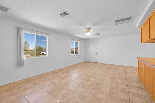 72454 El Paseo Dr Unit 29, Palms, CA 92277 - empty room featuring a textured ceiling, a ceiling fan, and light tile patterned flooring